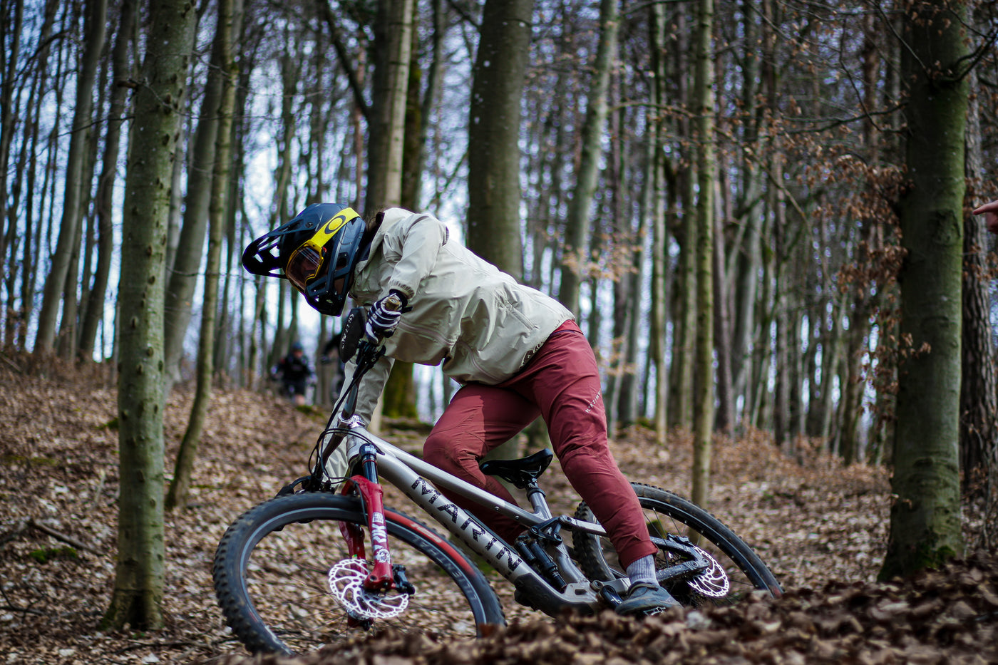 Lotta auf MTB mit grüner Jacke und roter Hose