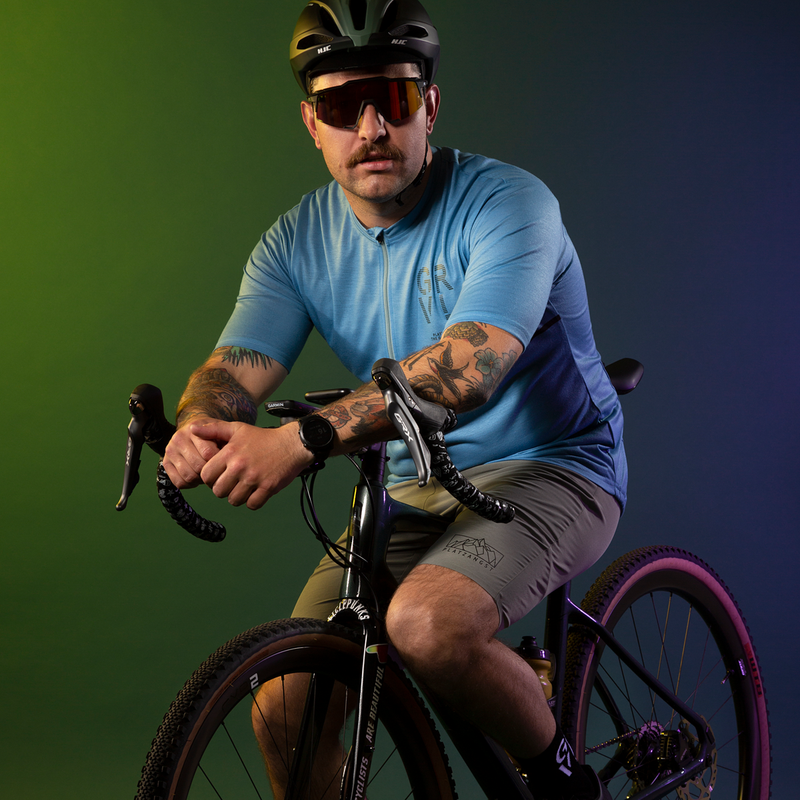 Detailbild Gravelfahrer auf Fahrrad sitzend vor buntem Hintergrund, Studiobild