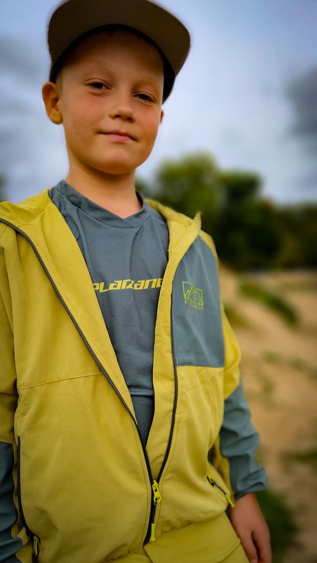 Junge mit Basecap und gelber Jacke