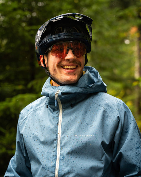 Mountainbiker in blauer Regenjacke
