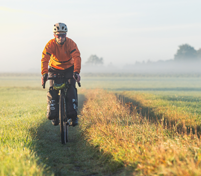 Banner Gravelbiker auf einem Feld