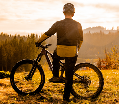 Banner Neuheiten im Shop, Mountainbiker vor Sonnenaufgang